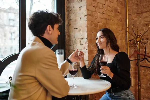A young couple shares a special moment over dinner, enjoying wine and deep conversation. — Stock Photo