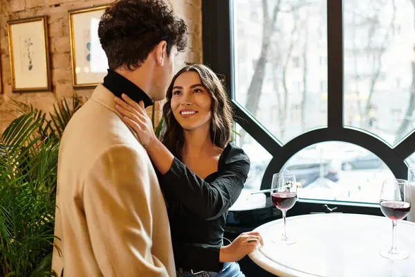 A young couple celebrates their love with smiles and wine during a charming dinner date. — Stock Photo
