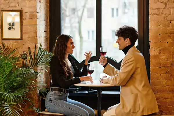 A young couple enjoys their Valentines Day dinner, toasting with glasses of wine in a cozy setting. — Stock Photo