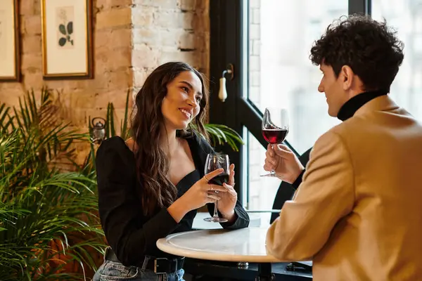 A beautiful couple toasts with wine, sharing smiles on a special valentines day evening. — Stock Photo