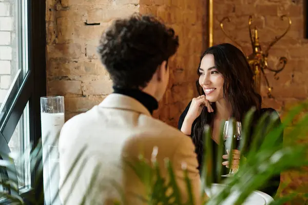 A lovely couple celebrates love with smiles and drinks in a cozy restaurant. — Stock Photo