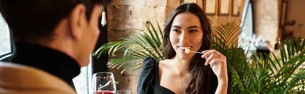 Celebrating love, the couple shares smiles and delicious food at a warm restaurant setting, banner — Stock Photo