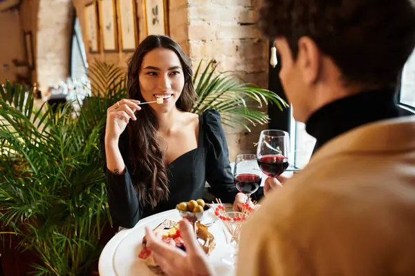 Una joven pareja disfruta de una comida especial mientras celebran su amor el día de San Valentín. - foto de stock