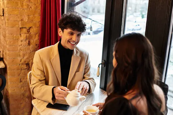 A young couple shares a joyful moment over tea while celebrating their love on Valentines Day. — Stock Photo