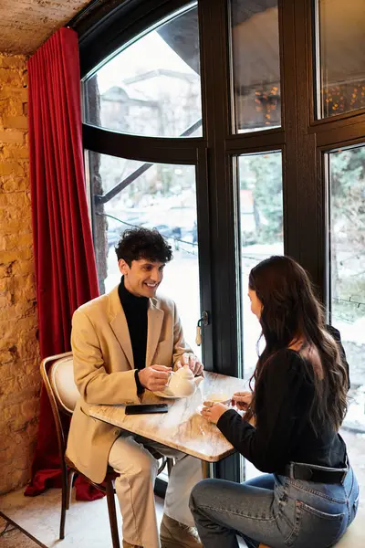 A young couple enjoys a special Valentines dinner, sharing smiles and drinks in a warm atmosphere. — Stock Photo