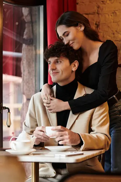 A loving couple joyfully embraces in a charming restaurant on their special day. — Stock Photo