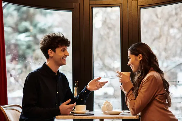 A beautiful couple celebrates their love in a cozy restaurant, enjoying each others company. — Stock Photo