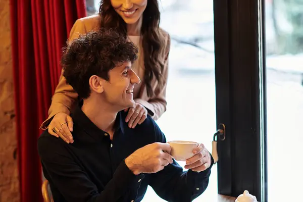 A young couple celebrates their love with smiles and cozy moments over coffee at a restaurant. — Stock Photo