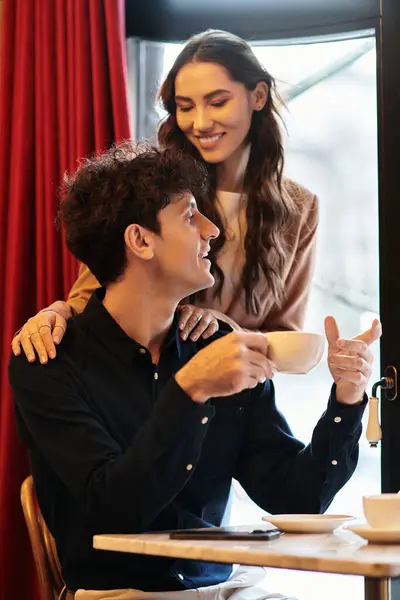 A young couple enjoys each others company over warm drinks, celebrating love together. — Stock Photo