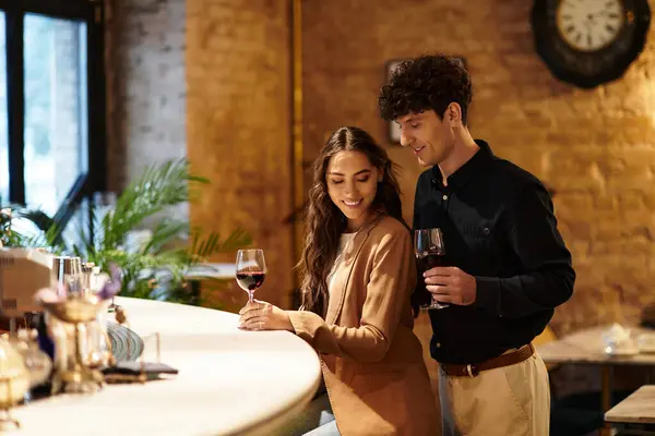A beautiful young couple enjoys their time together while sipping wine, celebrating love. — Stock Photo