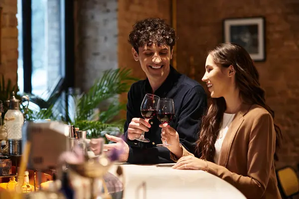 Young couple celebrates their love with cheers and laughter at a restaurant bar on Valentines Day. — Stock Photo