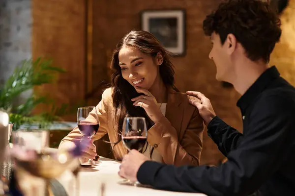 Ein Paar teilt intimes Lächeln und Lachen, während es in einem charmanten Restaurant Wein schlürft. — Stockfoto