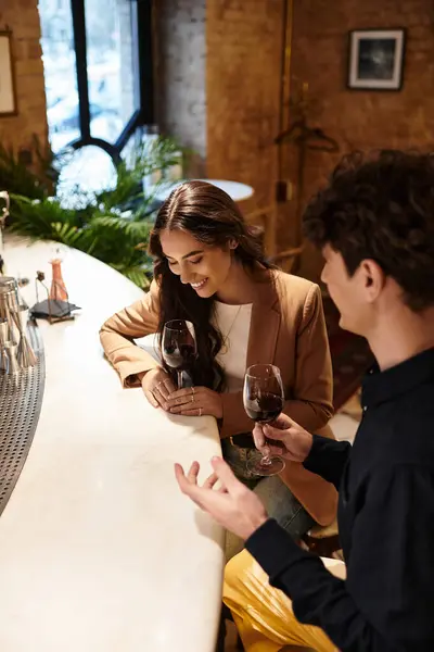 A young couple enjoys an intimate moment together, celebrating their love with wine and laughter. — Stock Photo