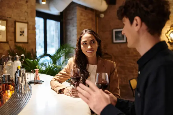 A young couple enjoys an intimate dinner at a cozy restaurant, sharing laughter and wine. — Stock Photo