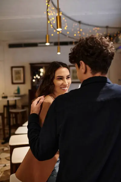 A young couple shares a joyful moment in a romantic restaurant, celebrating their love. — Stock Photo