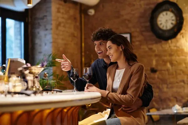 Jeune couple célèbre leur amour dans un charmant restaurant, le partage des rires et du vin. — Photo de stock