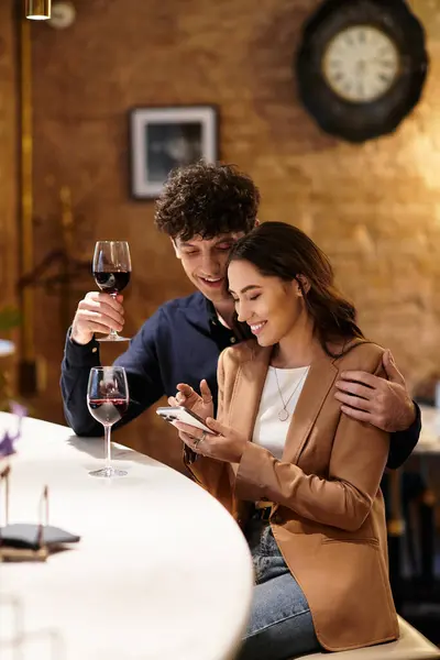 Un couple partage du vin et sourit, célébrant leur amour dans un cadre chaleureux. — Photo de stock