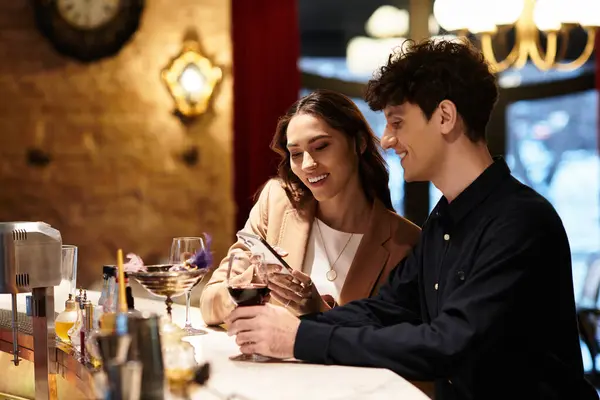 A lovely couple enjoys drinks and smiles while celebrating their special day at a restaurant. — Stock Photo