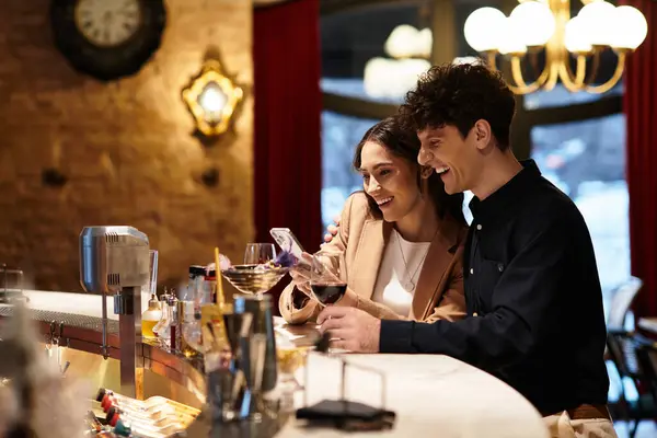 A lovely couple shares laughter and joy while celebrating their love at a restaurant bar. — Stock Photo