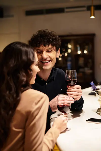 A lovely couple toasting with glasses of red wine during a special Valentines dinner together. — Stock Photo