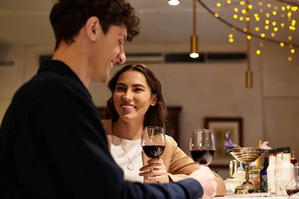 Romantic evening at a cozy restaurant where a couple smiles while enjoying each others company. — Stock Photo