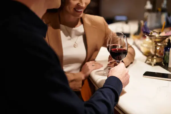 Young couple enjoys a romantic evening together, toasting with red wine in a charming restaurant. — Stock Photo