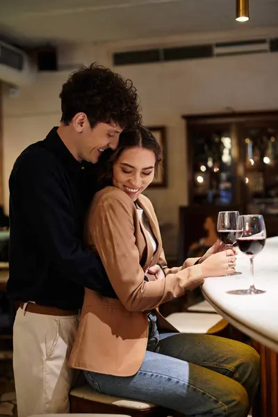 A young couple enjoys a romantic evening together, celebrating their love with wine. — Stock Photo