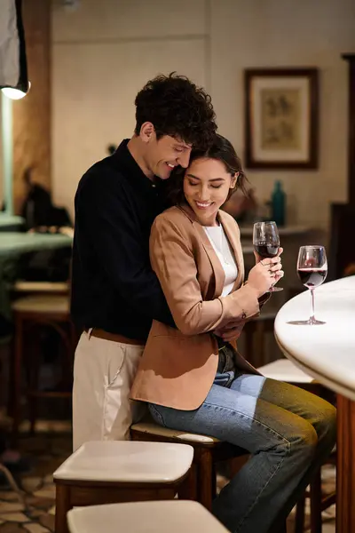 A young couple enjoys an intimate Valentines Day evening, sharing smiles and wine. — Stock Photo