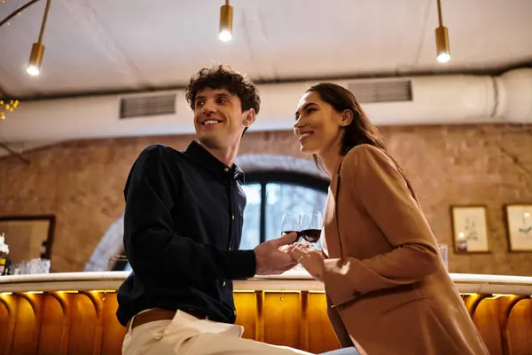 A young couple shares a joyful moment with glasses raised in celebration of their love. — Stock Photo