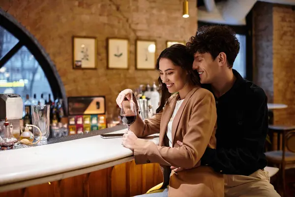 A young couple shares a loving moment, savoring their drink and celebrating love in a restaurant. — Stock Photo
