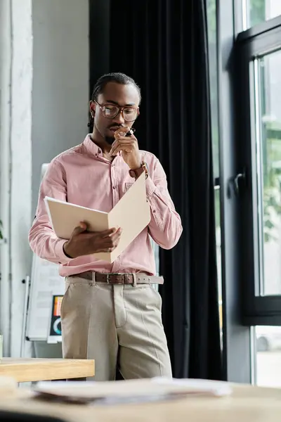 Focused young man reviews his notes while working in a vibrant coworking environment. — Stock Photo