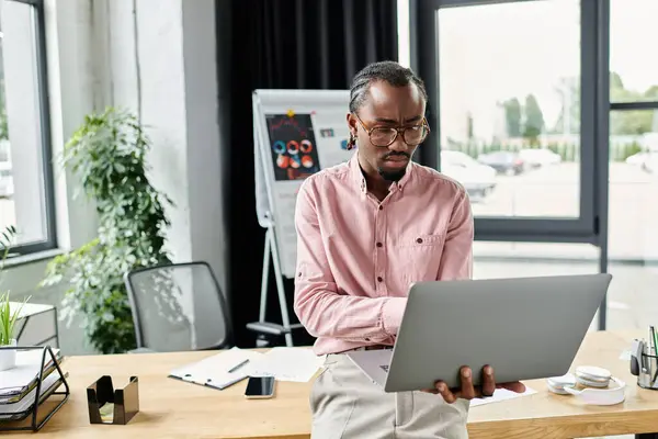 Focused young man engaged in digital work while exploring remote opportunities in a modern office. — Stock Photo