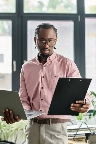 Focused young man organizes tasks while showcasing his digital nomad lifestyle in a modern office. — Stock Photo