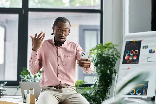 Young man expressing ideas during a video call while seated in a stylish office environment. — Stock Photo