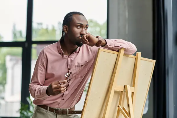 This young african american man is deep in thought as he prepares for his next artistic project. — Stock Photo