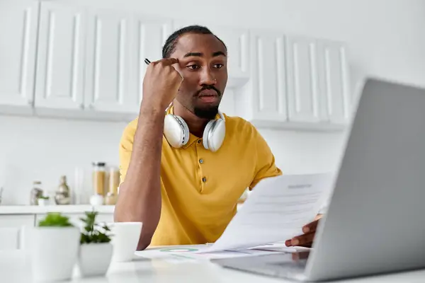 A young african american man focuses on remote work as he reviews key documents. — Stock Photo