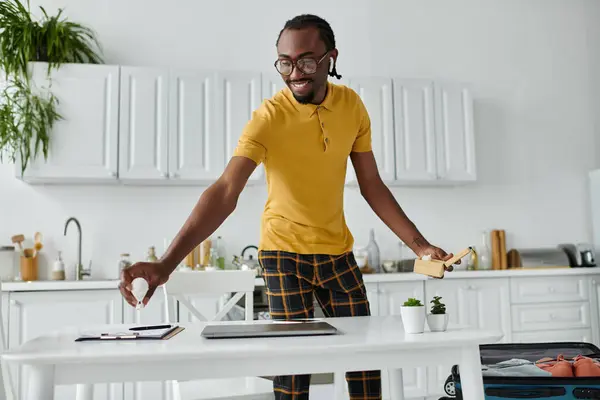 A handsome young man engages in remote work while organizing his space with enthusiasm. — Stock Photo