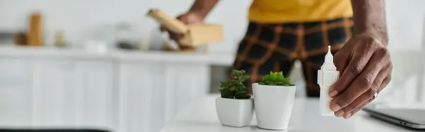 Un jeune homme afro-américain organise son espace de travail dans une cuisine chic tout en se concentrant sur ses tâches. — Photo de stock