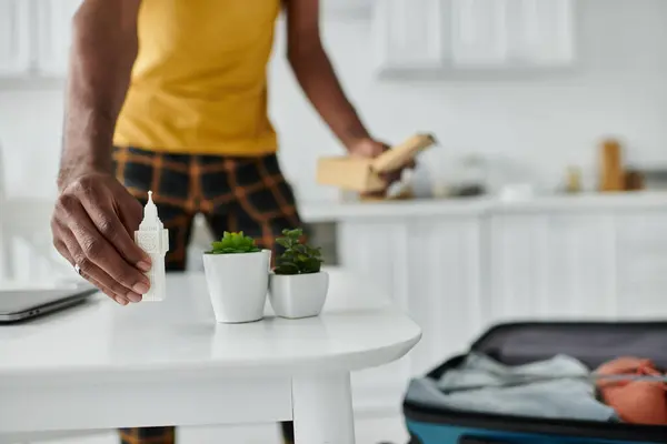 Un giovane uomo afroamericano mescola senza sforzo produttività e creatività mentre organizza il suo spazio di lavoro. — Foto stock