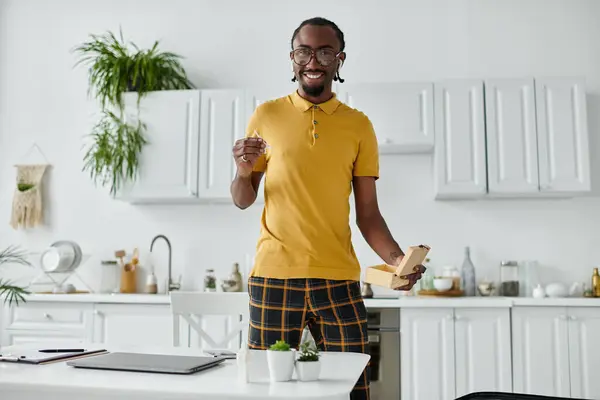 Um jovem alegre desfruta de seu trabalho e criatividade em um ambiente de cozinha elegante cheio de plantas. — Fotografia de Stock