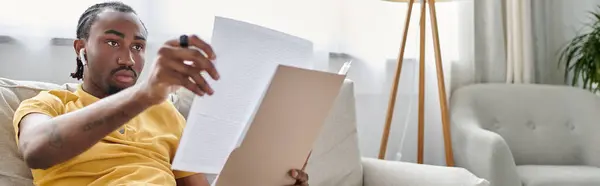 Focused individual enjoying remote work while reviewing important documents in a bright room — Stock Photo