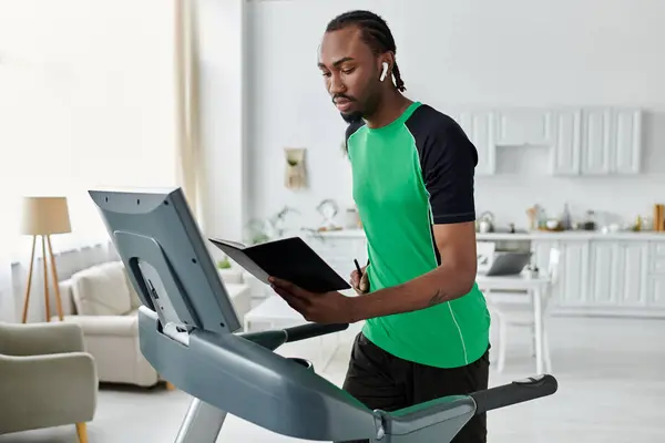 A young African American man in athletic wear balances fitness and productivity while walking. — Stock Photo