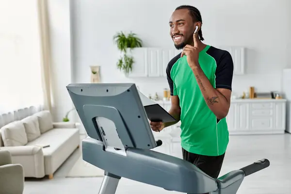 Um jovem afro-americano sorri enquanto equilibra aptidão e trabalha em uma esteira. — Fotografia de Stock