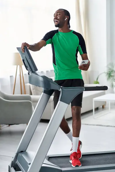 Energetic young man happily using treadmill while listening to music in a bright gym setting. — Stock Photo