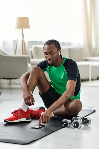 Focused on his workout, a young man balances fitness and remote work in a bright living space. — Stock Photo