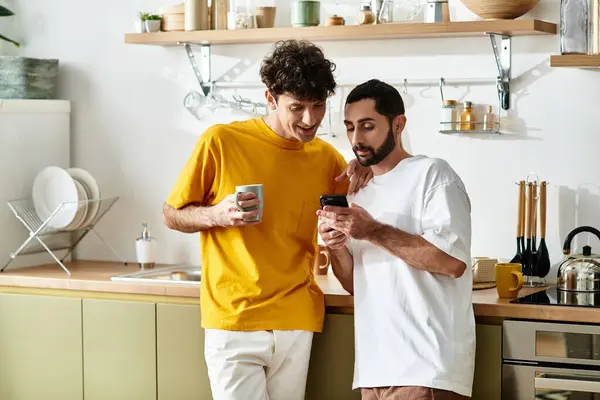 Due uomini condividono un momento gioioso nella loro cucina elegante, godendosi reciprocamente compagnia e risate. — Stock Photo