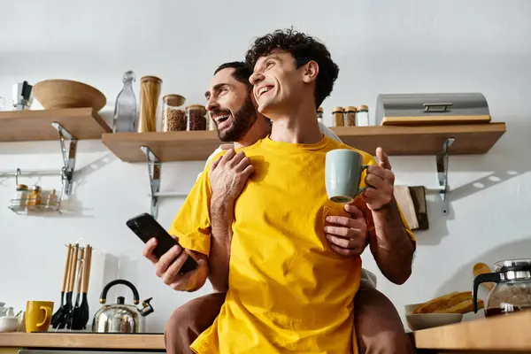 Two men enjoy each others company in their stylish apartment while sipping coffee together. — Stock Photo