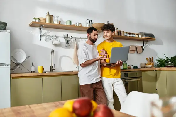 A loving couple shares a moment while exploring ideas on a laptop in their home. — Stock Photo