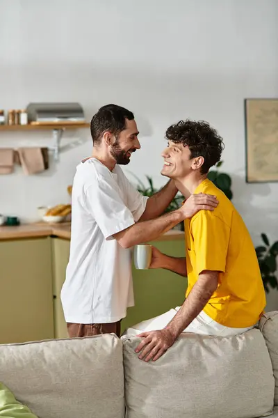 Two men express their affection in a cozy modern apartment, sharing laughter and warmth. — Stock Photo