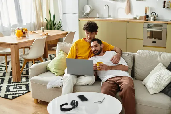 Two men share a tender moment on the couch, enjoying quality time together in their stylish home. — Stock Photo
